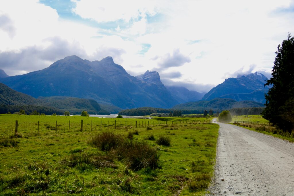 nature scene with a dirt road leading to mountains