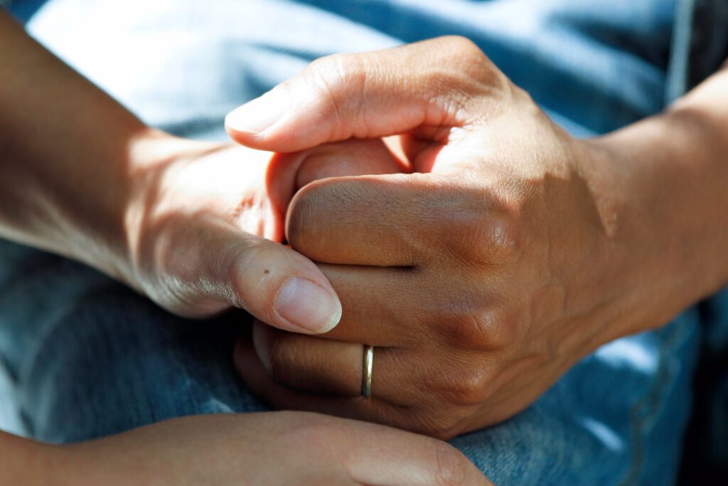 a cropped and zoomed photo of two people holdings hands