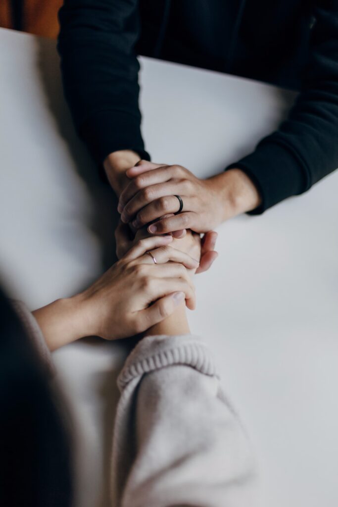 a closeup of two people holding hands, only their hands are visible