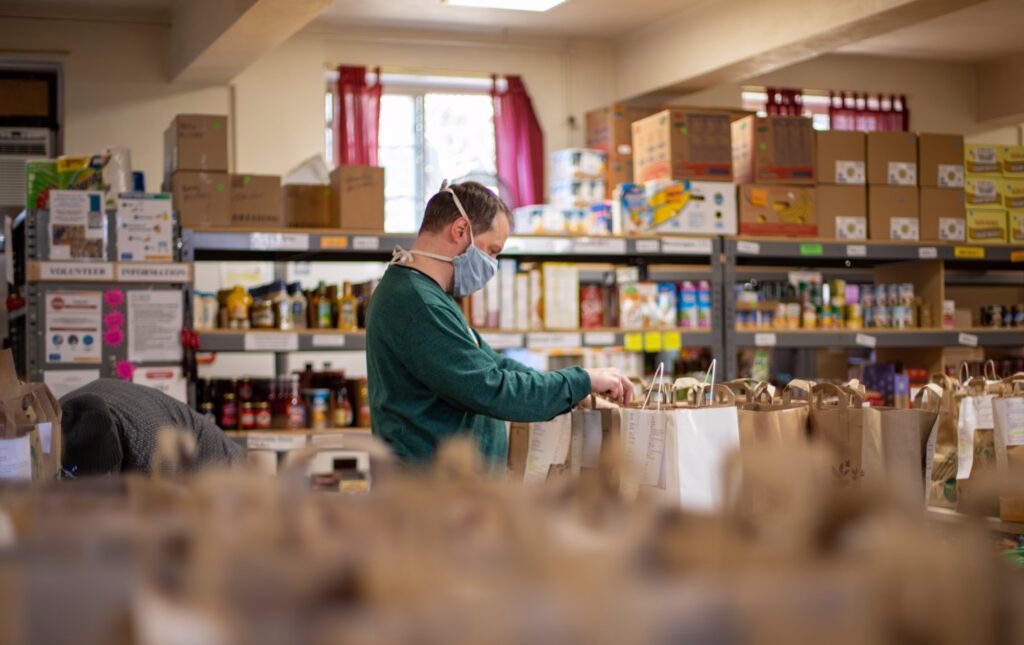 man working at a grocery store wearing a mask