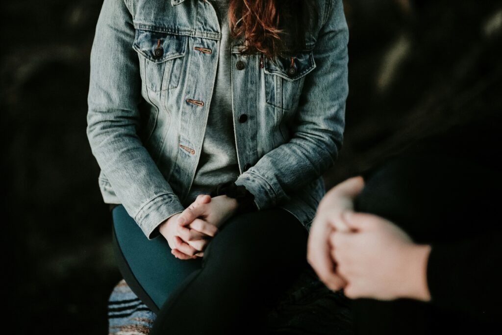 two people sitting down with their hands clasped